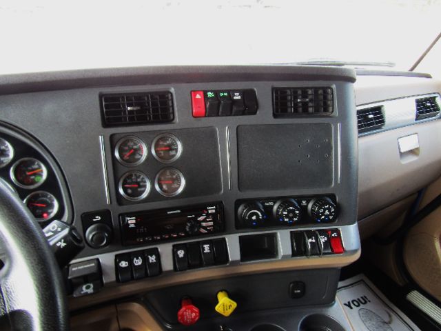 Dashboard of a Kenworth truck showing gauges, vents, switches, and climate controls. Visible labels include warning lights, circular gauges, and control panels.