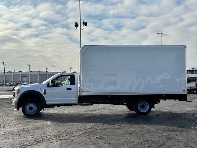 Ford F-550 box truck side view with white cab and box body, no visible branding on box, daytime outdoor lot.