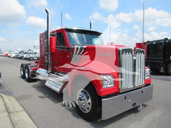 Kenworth W990 conventional sleeper truck in red with chrome grille and exhaust stacks, showing front and passenger side in a dealership lot.