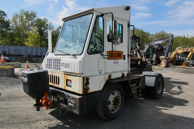 1997 Ottawa YT30 yard truck with white cab, black frame, and yellow 'YELLOW Hzrd' decal on door; some rust, diesel tank, and rear-mount counterweight visible.