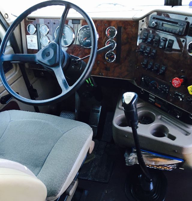 Interior dash of a 2007 International 9400I truck showing steering wheel, woodgrain dashboard, gauges, and gear shifter.