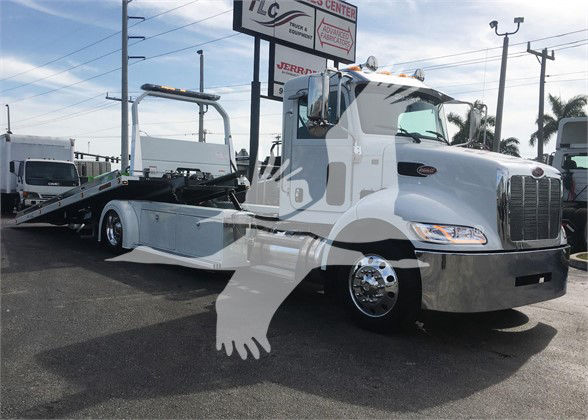 2022 Peterbilt 337 tow truck in a dealership lot with a lowboy trailer attached; visible text includes stock number J51806 and dealership sign in background.