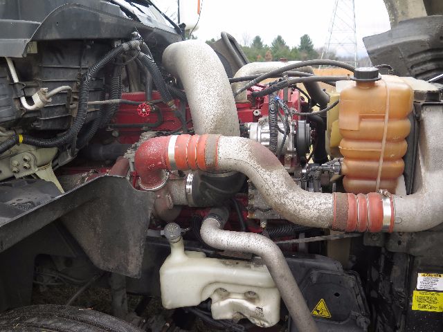 Engine bay of 2010 International PROSTAR showing large intake hoses, coolant reservoir, and various fluid lines.