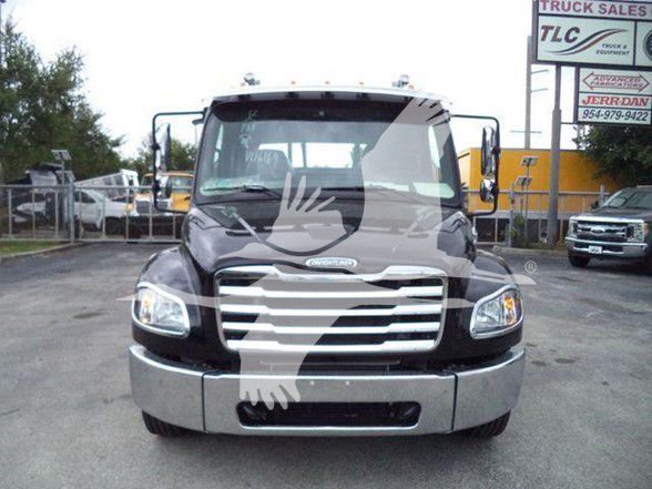 Freightliner M2 106 front view showing grille, headlights, and bumper. visible branding on hood and windshield, dealership lot in background.