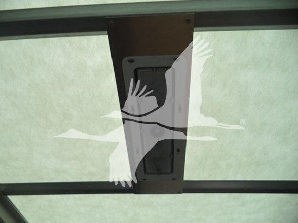 Vehicle interior roof showing a rectangular hatch/vent with surrounding brown frame and translucent ceiling panel.