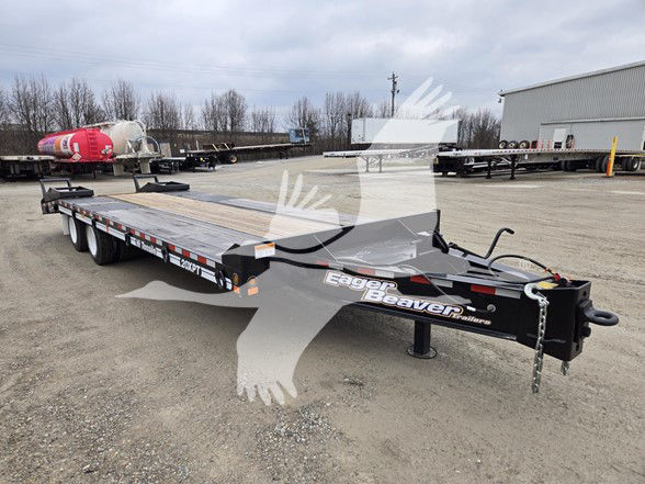 Eager Beaver 20 Xpt flatbed trailer in a yard showing dual axles, black frame, wooden deck, and Eager Beaver branding on the tongue.
