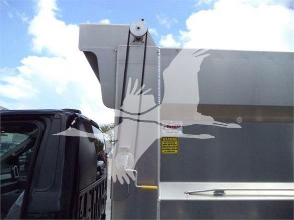 Ford F-550 truck bed side with tailgate latch and warning label visible.