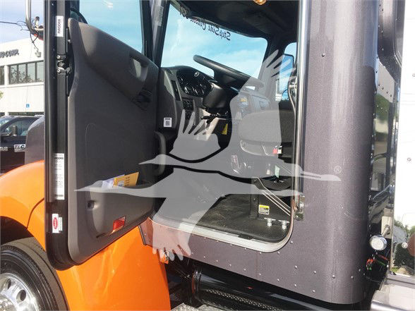 Peterbilt 337 truck cab interior visible with open door, dashboard and steering wheel, orange fender, and step area.