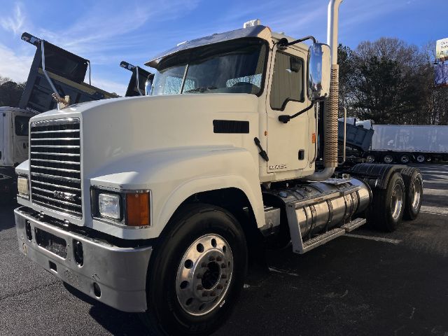 Truck engine bay area not visible; cab side view of a white 2013 Mack CHU613 Pinnacle conventional daycab.