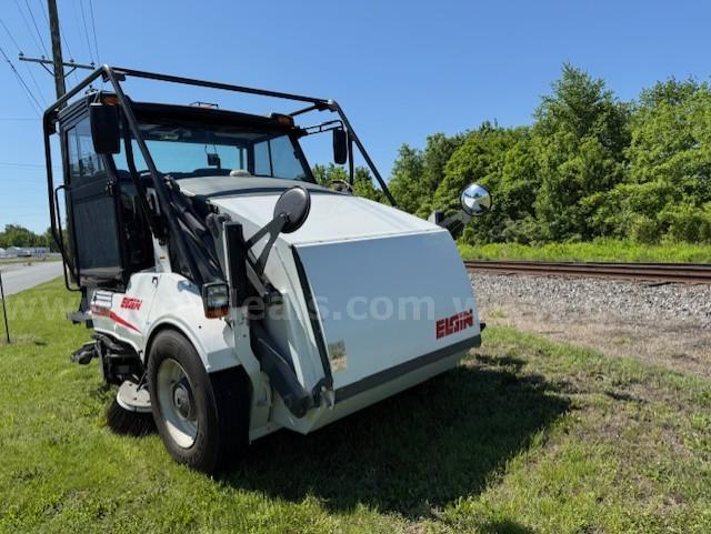 Elgin Pelican NP sweeper truck in service showing front plow attachment and Elgin branding.