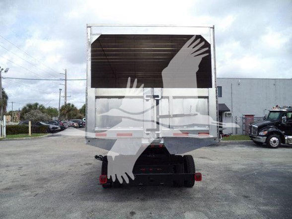 Rear view of a Chevrolet Silverado 6500HD dump truck with a metal dump bed and tailgate, showing the back end and wheels.