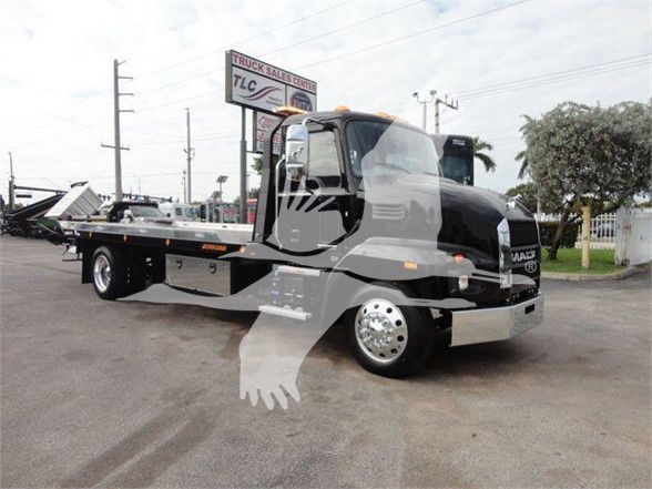 Truck showing Mack MD6 cab and flatbed tow truck with VIN plate and stock info in background sign