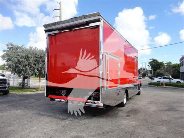 Mack MD6 tow truck rear/right side view with red cargo box and chrome accents.