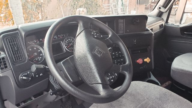 Interior view of a 2019 International conventional truck showing steering wheel, dashboard gauges, and driver seat.