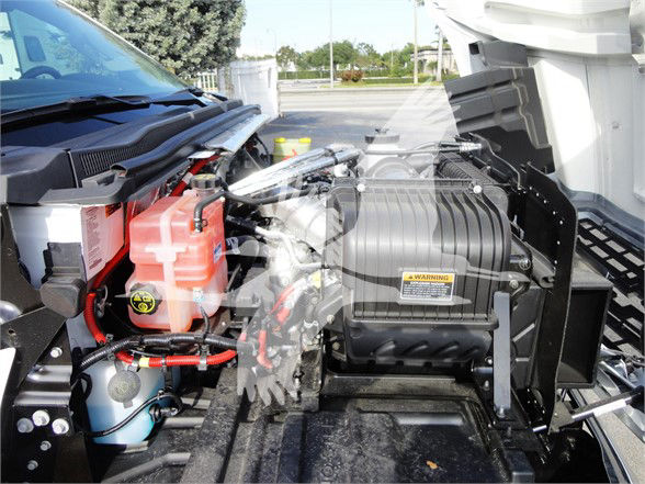 Chevrolet Silverado 5500HD engine bay showing coolant reservoir and air filter housing with warning label.