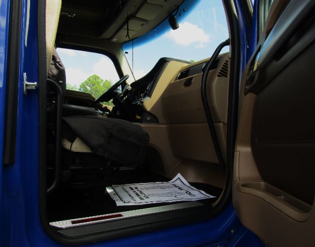 Kenworth T680 truck interior cabin view from driver side door with dashboard and seat visible.
