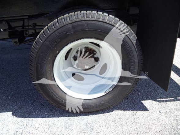Wheel of a Ford E450 dump truck showing tire and white steel rim, no visible logos or other text.
