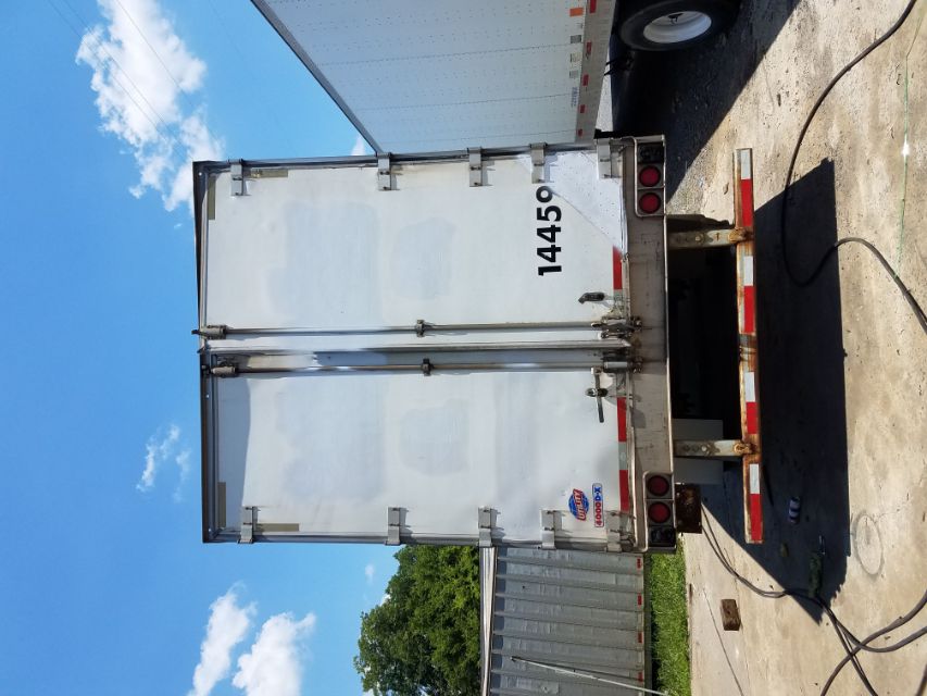 Rear view of a white utility trailer box doors with latches and hinges, number 14459, small Utility logo sticker on left, red/white reflective tape along bottom edge.