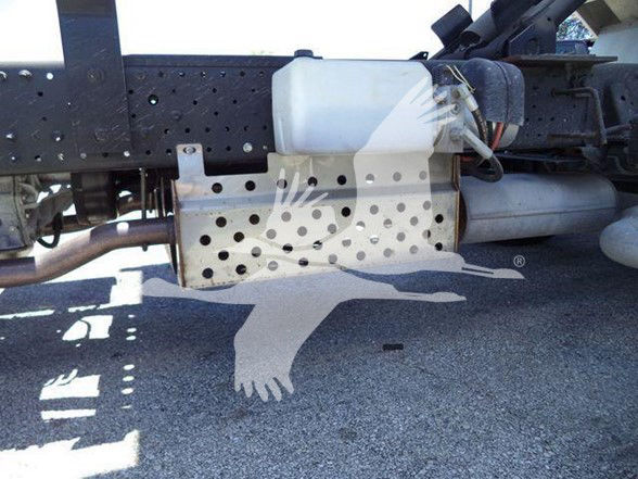 Isuzu NQR truck chassis underside with perforated metal frame and white reservoir; visible pipes and frame components.