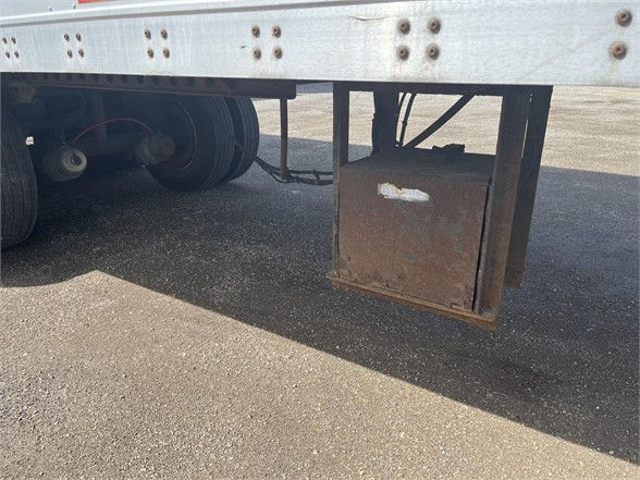 Trailer underside showing a rusted drop-down toolbox mounted under a Wabash dry van trailer.