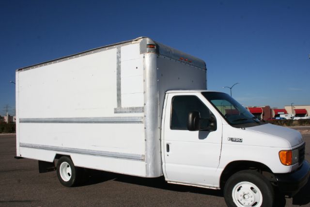 Box truck with a white cab and large white cargo box, Ford E-350 badge visible on front fender.
