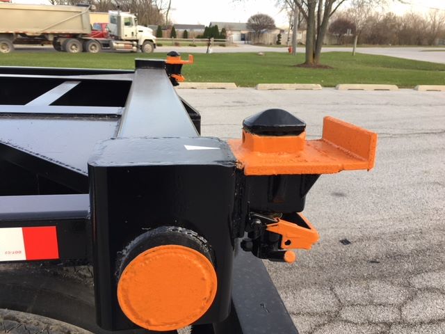Trailer hitch area of a 2003 Wabash tipper trailer showing bright orange circular cover and orange mounting brackets.