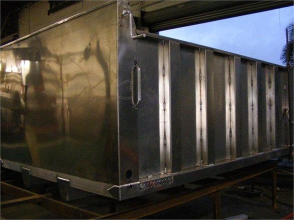 Dump body truck bed showing metal sides and rear corner, stock number 12TD48PS, stainless steel construction, new condition.