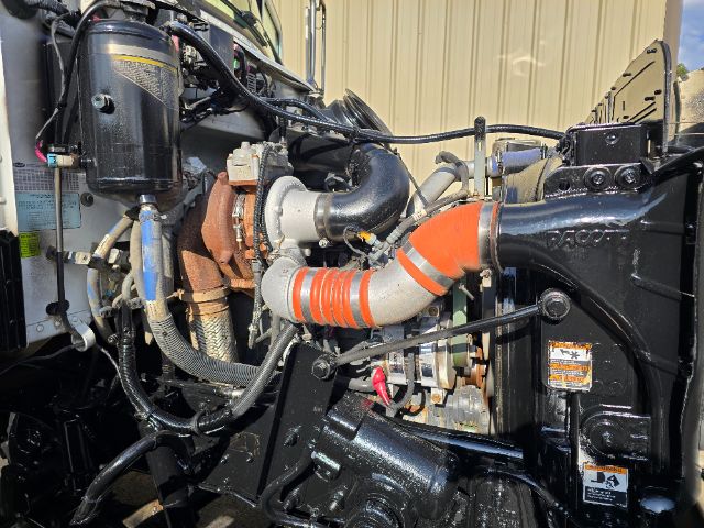 Peterbilt 348 engine bay showing turbocharger, coolant hoses, and air intake with orange hose clamp.