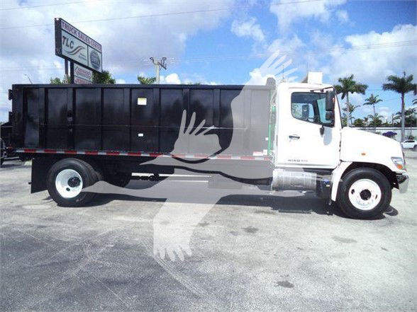 Dump truck side view showing cargo bed, cab, and wheels; 2016 Hino 268A in used condition.