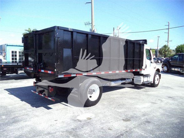 Dump truck in service showing cargo bed and rear view with Freightliner branding not visible.