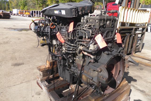 Detroit DD13 engine core on pallet with various hoses and tags attached, viewed from side, used stock number 1158E