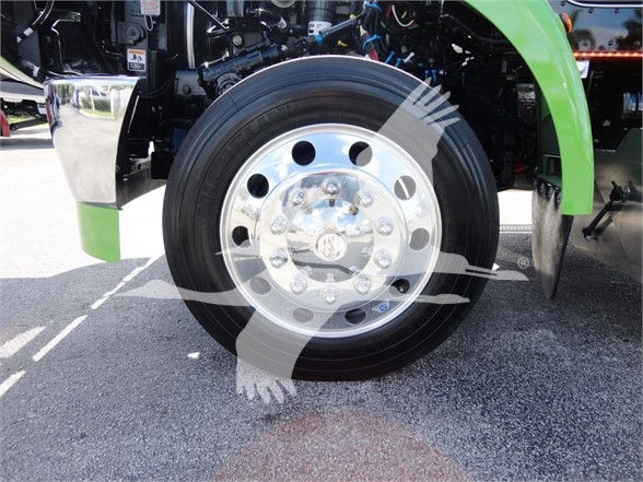 Peterbilt 337 front wheel and chrome hub showing front tire and green fender.