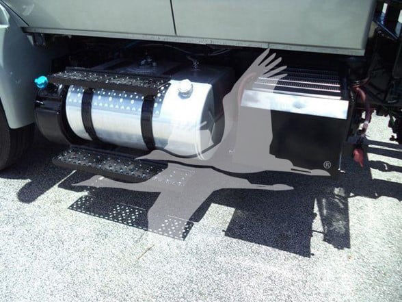Truck side showing large cylindrical fuel tank and side steps under the cab.