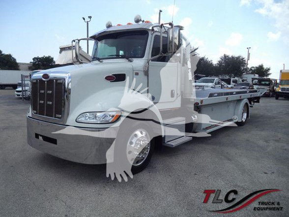 2022 Peterbilt 337 tow truck in a light color with flatbed, front grille, and side steps visible.