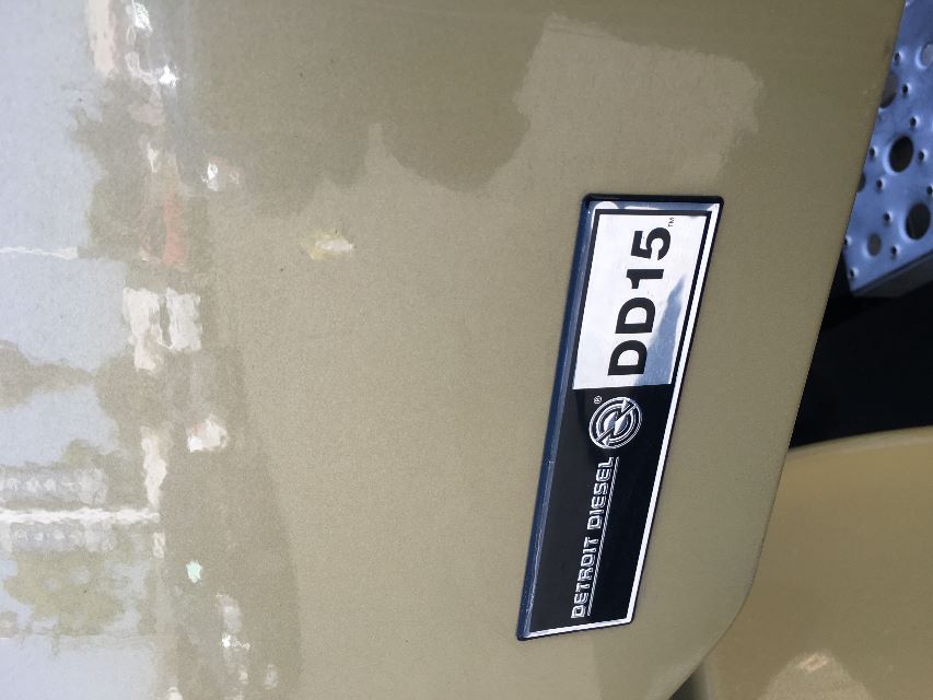 Freightliner Cascadia 125 engine bay badge showing Detroit Diesel DD15 logo on beige exterior.