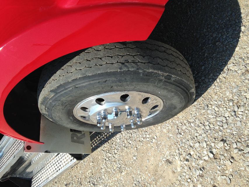 Kenworth T800 wheel and red fender showing front tire and chrome lug nut covers.
