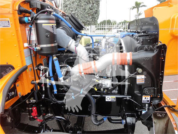 Peterbilt 337 engine bay with blue hoses, black radiator, and orange body panels visible.