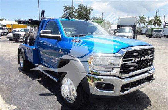 Ram 4500 tow truck in blue with chrome grille and dual rear wheels, front angle view showing RAM logo and bumper.