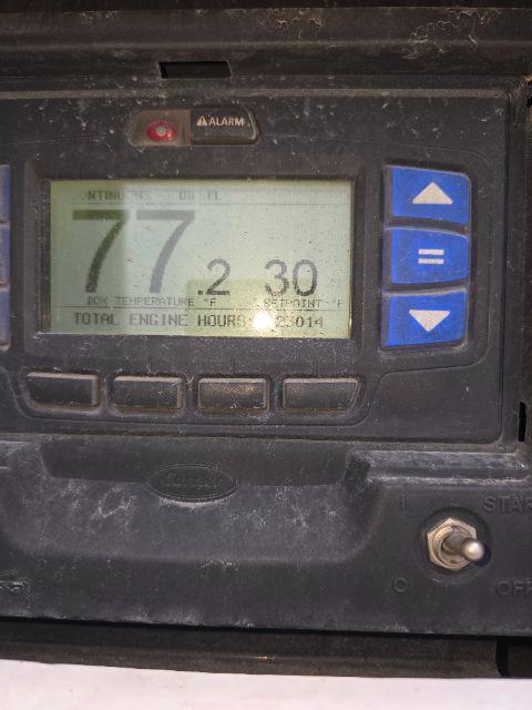 Great Dane trailer dimly lit control panel showing digital display with numbers 77 2 30, and blue arrows on right. Alarm indicator at top, control buttons below, rugged enclosure with grime.