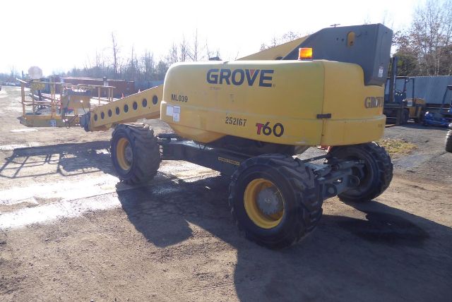 Grove T60 service crane on a wheeled chassis with extended boom, yellow body, GrovE logo, and large tires.