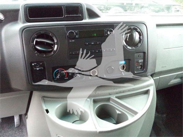 Ford E-450 dashboard showing center radio, climate controls, cup holders, and storage pockets.