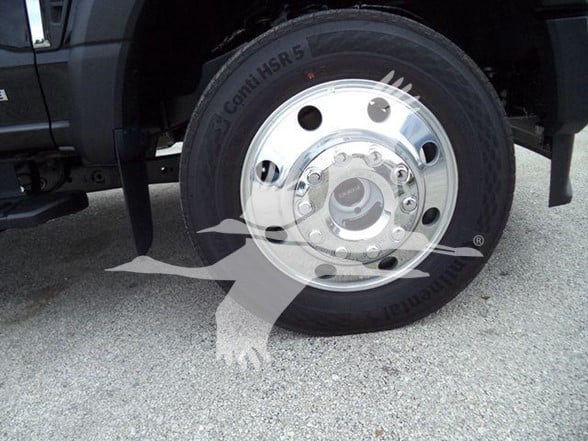 Wheel and tire on a 2024 Ford F450 tow truck, chrome rim with multiple lug nuts and Canih SS tire visible.