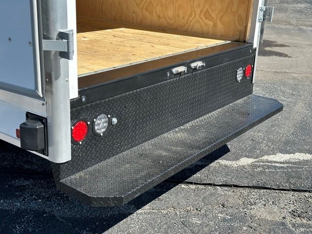 Box truck rear showing diamond plate step and taillights with wood cargo area.