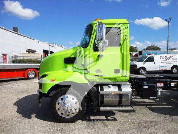 2025 Mack MD6 truck cab in lime green color side view showing front wheel, fuel tanks, and steps.
