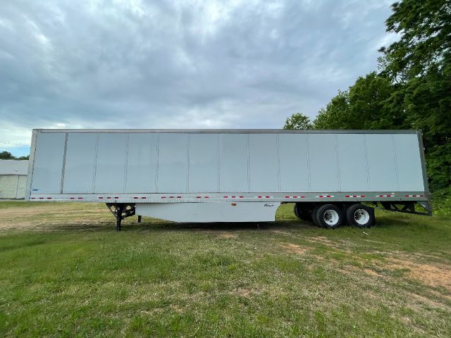 Trailer side view showing large gray Vanguard 53 ft trailer with dual rear axles and landing gear.