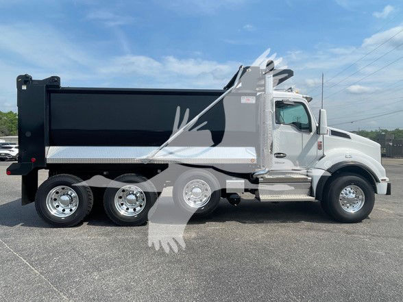 Kenworth T880 dump truck side view showing black dump bed, silver cab, chrome exhaust and wheel wells.