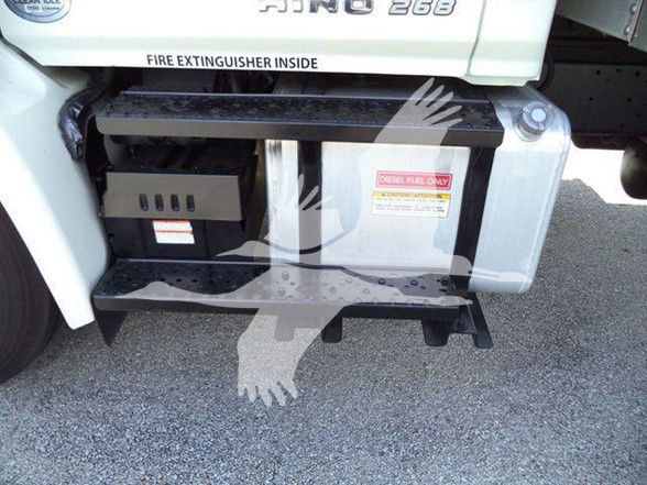 Truck side showing fuel/diesel step with warning label and chassis area.