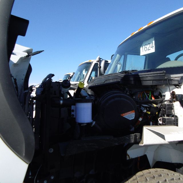 Truck engine bay of a 2016 International 7400 SBA 6x4 showing engine components, hoses, and a white coolant reservoir.
