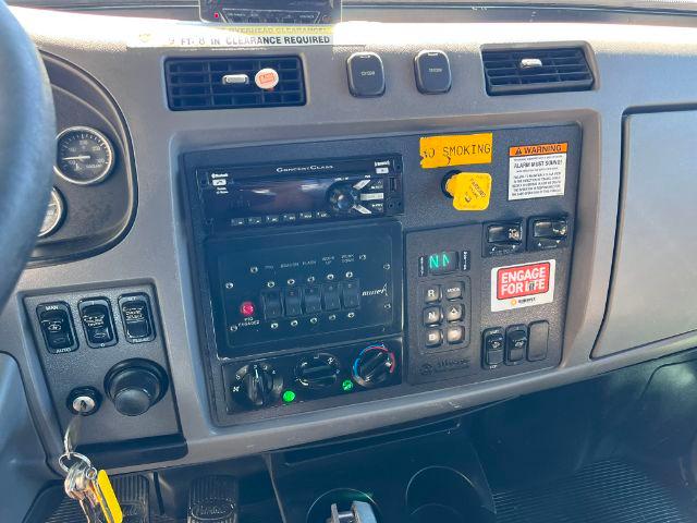 Peterbilt 348 dashboard area showing radio, climate controls, and various switches with labels like NO SMOKING and ENGAGE FOR LIFE.