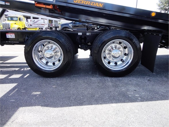 Kenworth W990 wheel set showing dual rear axles with polished chrome rims and black frame.